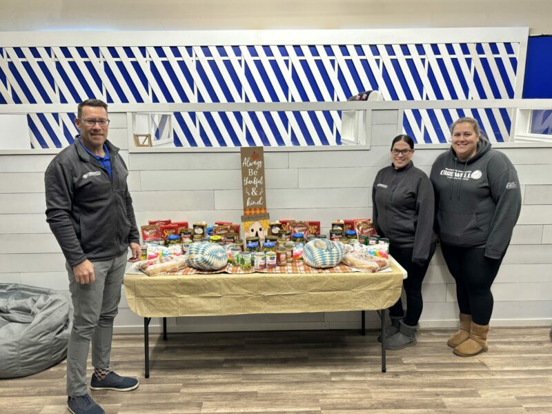 Thanksgiving basket donation 2023! Bob Cardwell standing with his team next to the table full of donations.