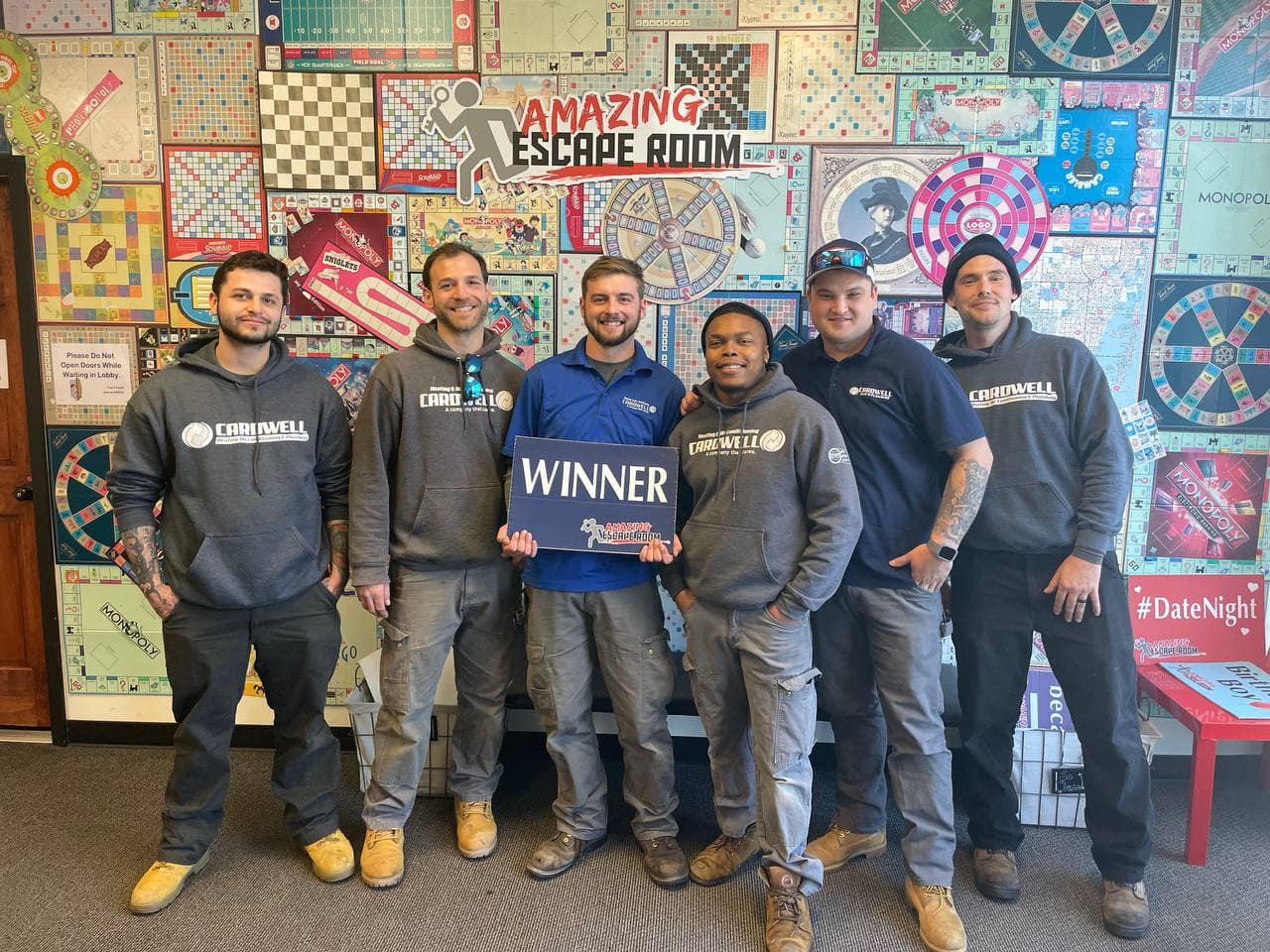 Team holding "Winner" sign.